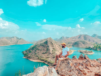 Man looking at view of mountain against sky