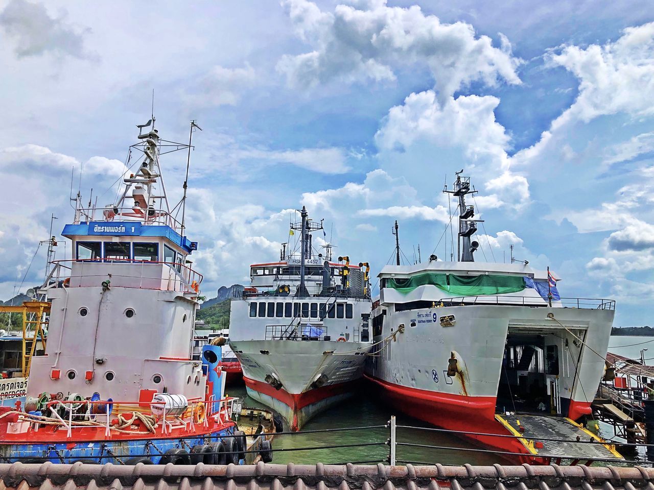 FISHING BOATS MOORED ON HARBOR AGAINST SKY