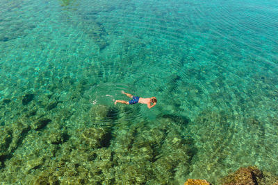 High view of a male snorkeling in crystal clear blue water in croatia.