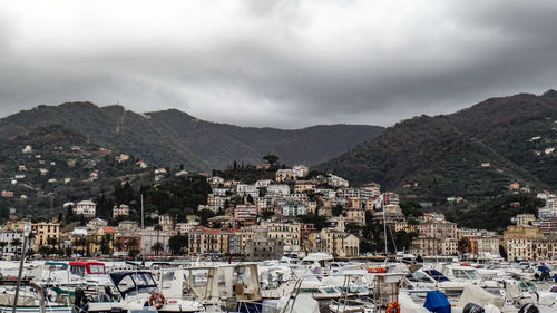 Aerial view of townscape by mountains against sky