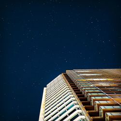 Low angle view of skyscraper against sky at night