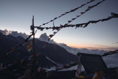 Barbed wire on mountain against sky during sunset