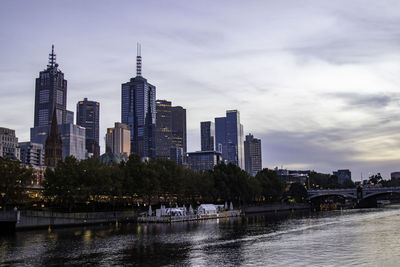 River by buildings against sky in city