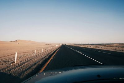 Road amidst landscape against clear blue sky