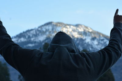 Rear view of person against sky during winter