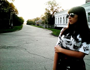 Young woman standing by house