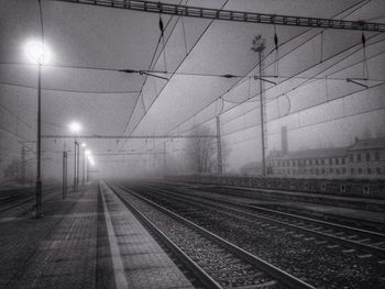 Railroad tracks against sky at night