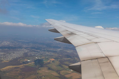 Airplane flying over landscape against sky