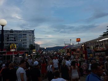 People on street in city against sky