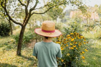 Rear view of man wearing hat against plants