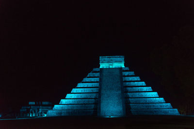 Low angle view of illuminated staircase against clear sky at night