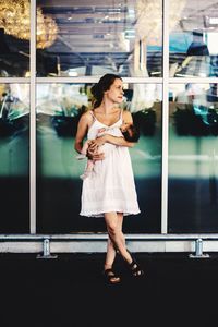 Full length of woman looking through glass window