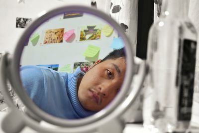 Close-up of man reflecting on mirror