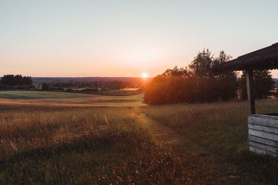 Scenic view of field against clear sky during sunset