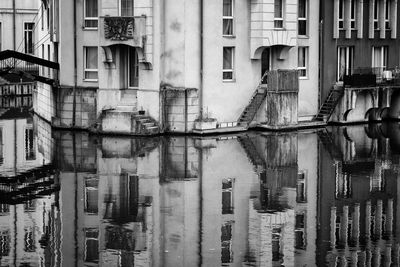 Old buildings built directly into the moselle river with reflections in metz, france