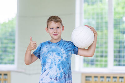 Portrait of boy standing against wall