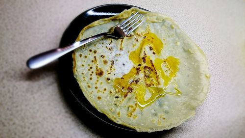 High angle view of pancake with honey on plate