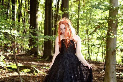A girl in a black dress in the forest
