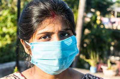 Portrait of woman wearing mask standing outdoors