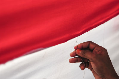 Close-up of human hand on red fabric