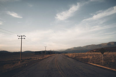 Empty road against sky during sunset