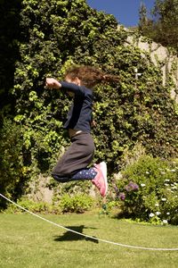 Side view of man jumping against trees