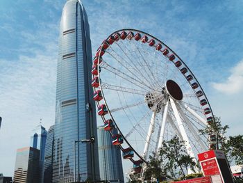 Low angle view of ferris wheel against buildings