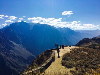 People standing on mountain road against sky