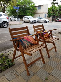 Empty chairs on street in city