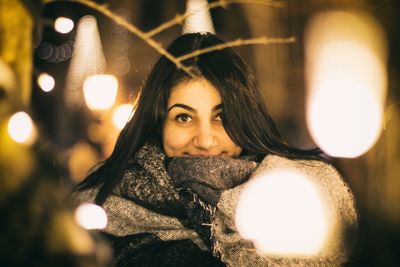 Portrait of woman with illuminated lights at night