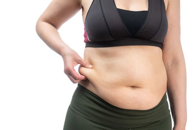 Midsection of woman standing against white background