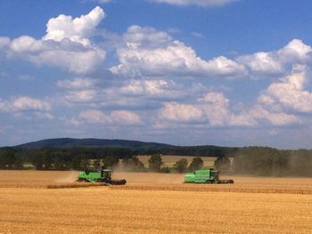 Scenic view of field against cloudy sky