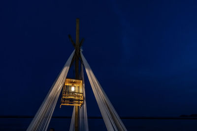 Low angle view of illuminated light bulb against sky at night