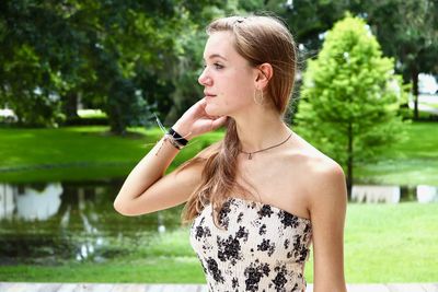 Young woman looking away against plants