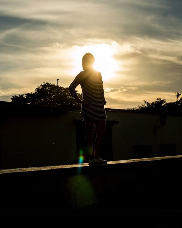 sunset, full length, sky, lifestyles, sun, rear view, silhouette, standing, leisure activity, sunlight, cloud - sky, railing, casual clothing, men, tree, childhood, lens flare, sunbeam