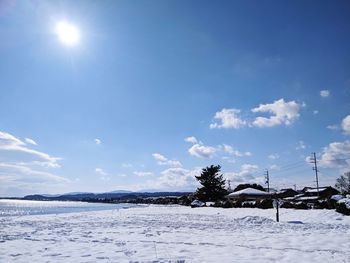 Scenic view of snow covered field against sky