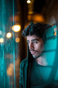 Close-up of young man looking through window