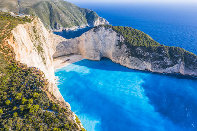 Aerial view of navagio beach - shipwreck beach - on zakynthos island, greece. tourists on cliff. 