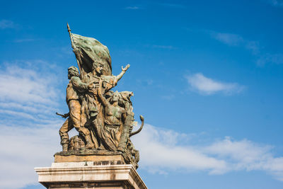 Low angle view of angel statue against cloudy sky