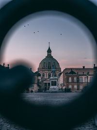 Buildings in city against sky during sunset