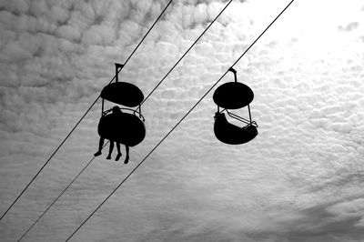 Low angle view of shoes hanging on cable