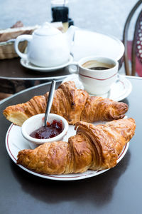 Breakfast with croissants and jam on table