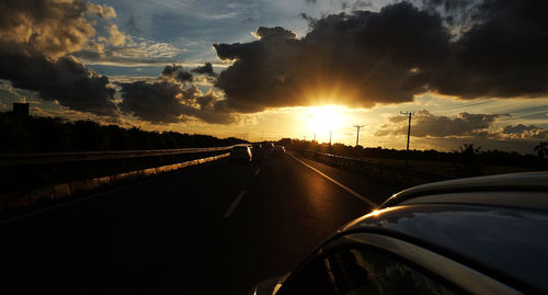 Car on road against sky during sunset