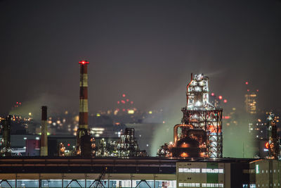 Illuminated buildings in city against sky at night