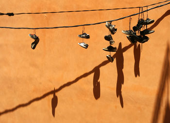 Low angle view of shoes hanging on cable