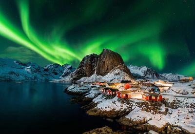 Scenic view of illuminated snowcapped mountains against sky at night