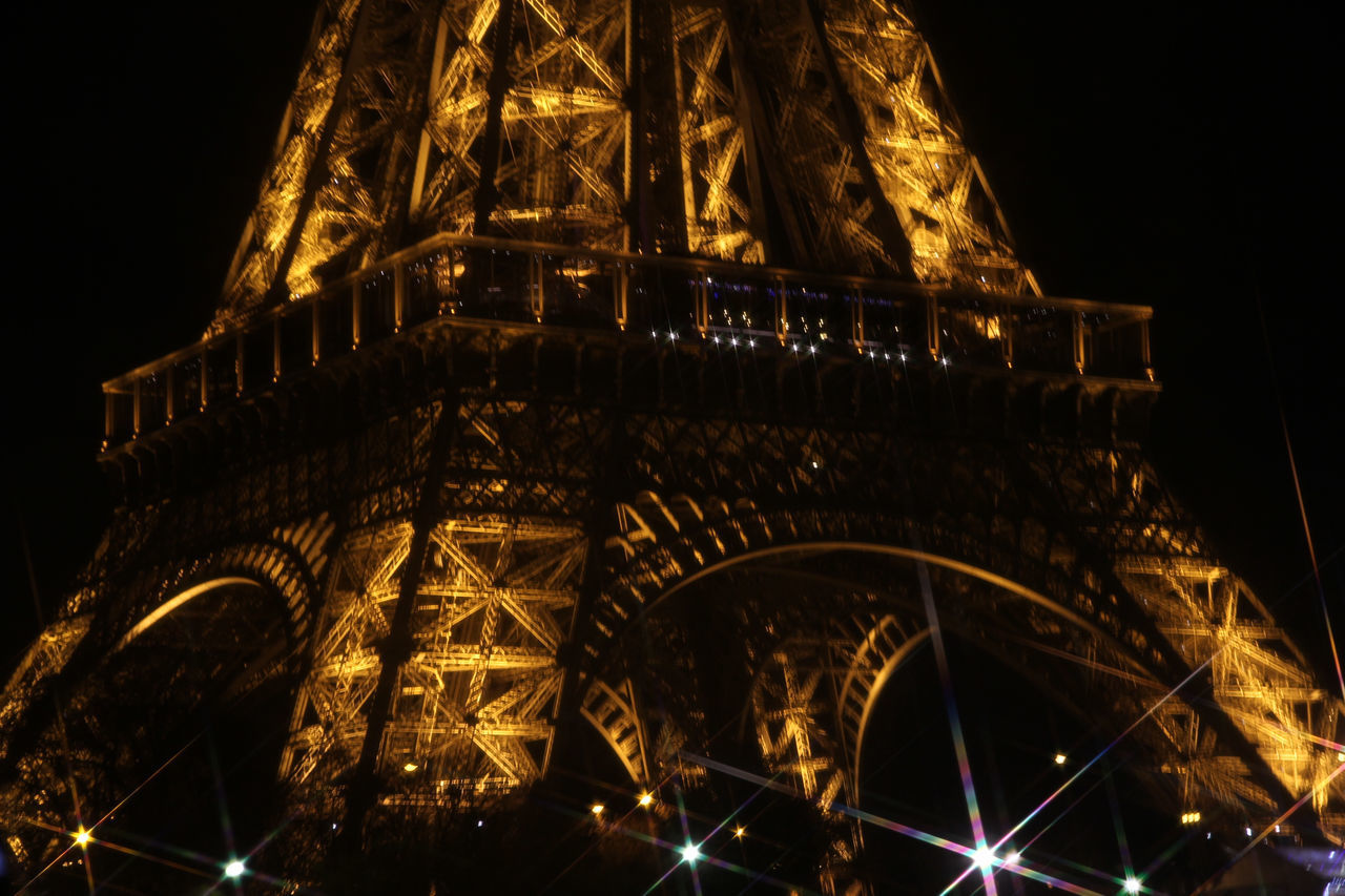 LOW ANGLE VIEW OF ILLUMINATED BUILDING AGAINST SKY AT NIGHT