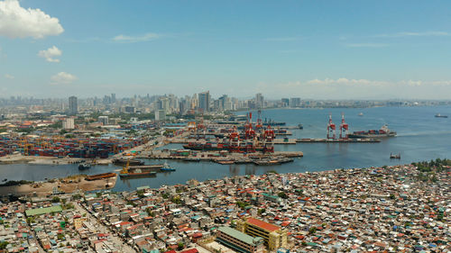 Manila city with port, skyscrapers, modern buildings and makati business center aerial drone.