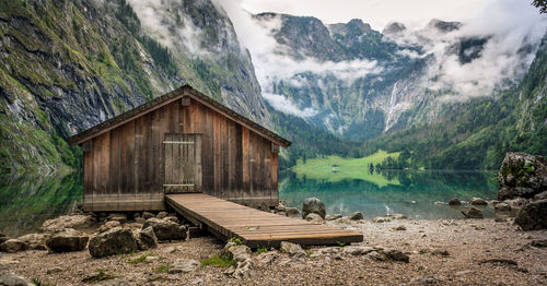 Log cabin by obersee lake amidst mountain during foggy weather