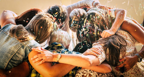 Group of people huddling while partying at home